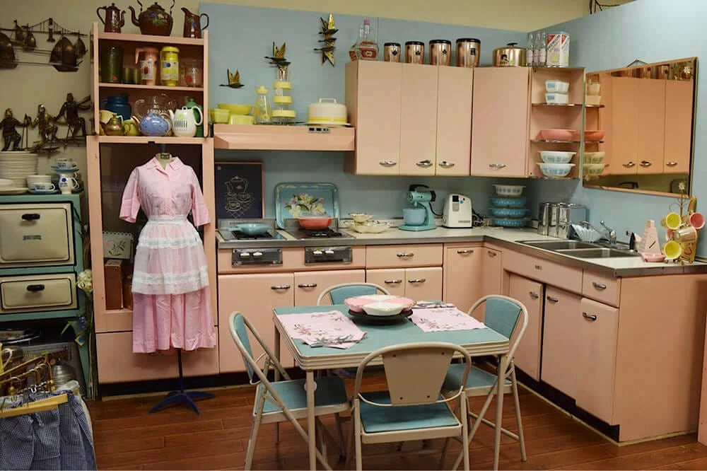 Vintage 1950s kitchen with pale salmon pink steel cabinets and blue walls
