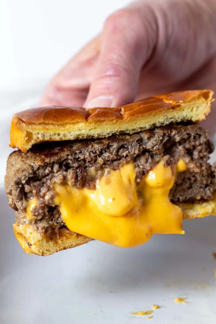 Air fryer Juicy Lucy burger oozing melted cheese from the center